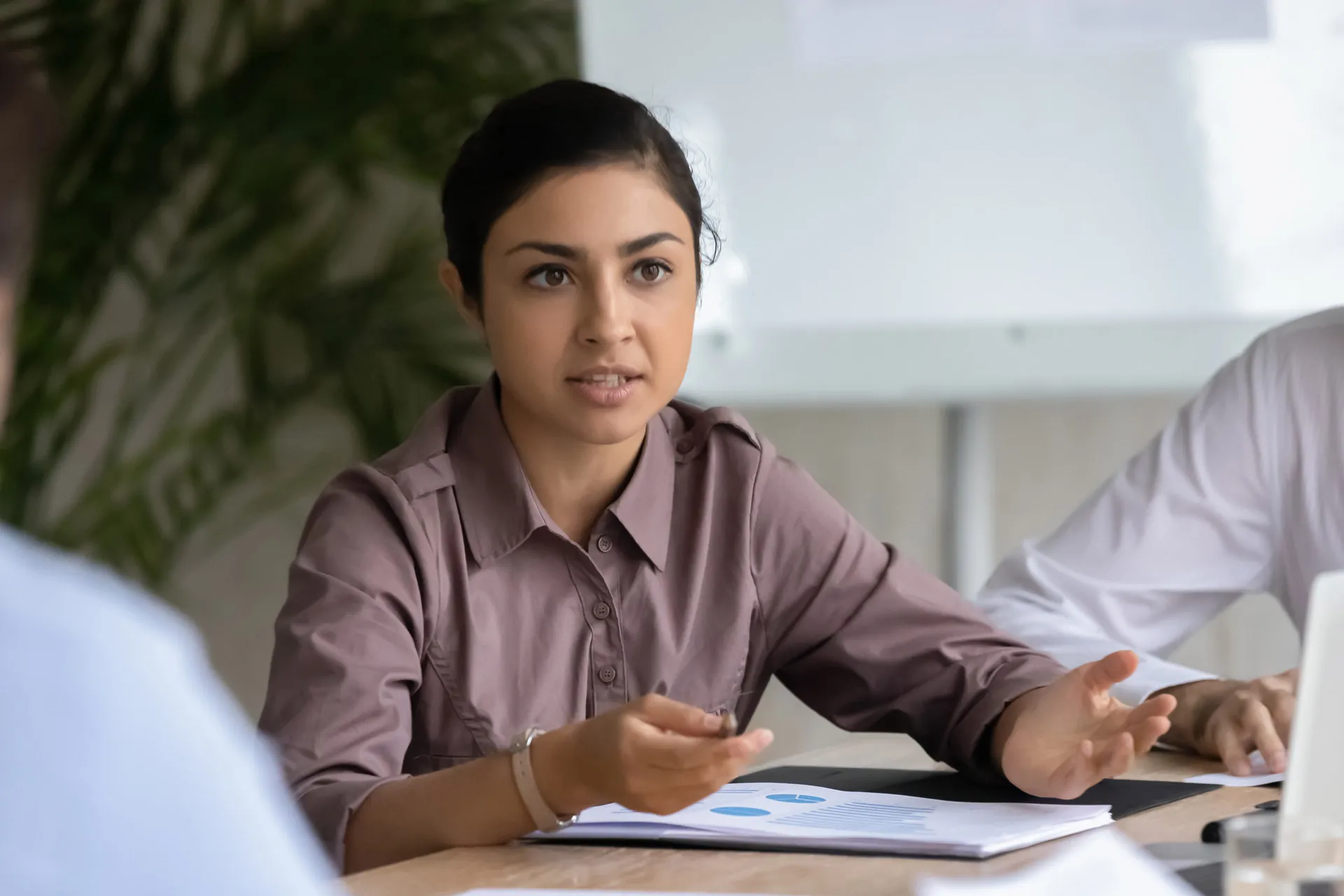 A confident woman engaged in conversation during a meeting.