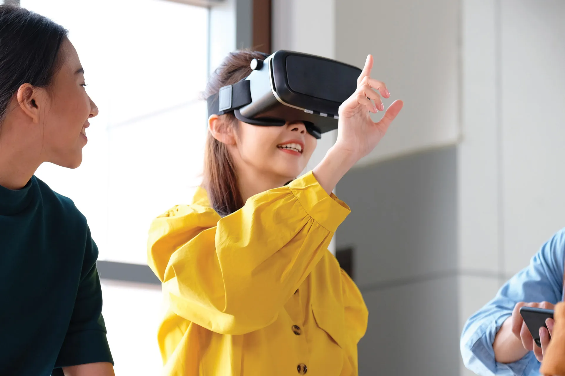 A woman wearing VR glasses, actively engaging with the virtual reality experience.